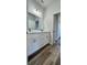 Bathroom with double vanity, framed mirror, and wood-look flooring at 559 Marion Oaks Blvd, Ocala, FL 34473