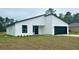 Modern home featuring a black garage door, window frames, white siding, and minimalist landscaping at 559 Marion Oaks Blvd, Ocala, FL 34473