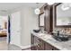 Bathroom with granite counter, bowl sinks and modern light fixtures, and a doorway leading to a bedroom at 8048 Canyon Lake Cir, Orlando, FL 32835