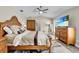 Comfortable bedroom featuring a wood bed frame, vaulted ceiling, and a large dresser with a TV on top at 8048 Canyon Lake Cir, Orlando, FL 32835