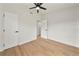 Bedroom with a ceiling fan, wood-look flooring, doors, and bright natural light at 133 Pinecrest Dr, Sanford, FL 32773