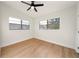 Bright bedroom featuring hardwood floors, a ceiling fan, and natural light from the two windows at 133 Pinecrest Dr, Sanford, FL 32773