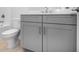 Close-up of bathroom with modern gray cabinet and toilet at 2990 Arranmore Dr, Ormond Beach, FL 32174