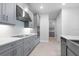 Stylish kitchen boasts gray cabinets, stainless steel hood, and sleek cooktop at 2990 Arranmore Dr, Ormond Beach, FL 32174