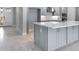 Open-concept kitchen featuring gray cabinets, a center island, and seamless access to other rooms at 2990 Arranmore Dr, Ormond Beach, FL 32174
