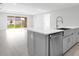 Well-appointed kitchen featuring gray cabinets, a center island, and a stainless steel dishwasher at 2990 Arranmore Dr, Ormond Beach, FL 32174
