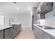 Gray cabinets, stainless steel appliances, and a sleek cooktop highlight this modern kitchen at 2990 Arranmore Dr, Ormond Beach, FL 32174