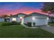 One-story house with a two-car garage, landscaped lawn, and a charming front entrance at 401 Montara Dr, Davenport, FL 33897