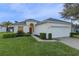 House exterior showcasing a two-car garage, manicured lawn, and inviting front porch at 401 Montara Dr, Davenport, FL 33897