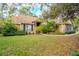 One-story house with tan siding, stone accents, and a landscaped lawn at 6408 Shoreline Ct, St Cloud, FL 34771