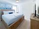 Calming bedroom with a wood bed, dresser, tv and blue decor at 8956 Zurich Ln, Kissimmee, FL 34747
