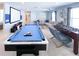 Spacious game room with a pool table, foosball table, large sofa, and theater setup at 8956 Zurich Ln, Kissimmee, FL 34747