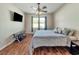 Spacious bedroom with large bed, TV, and hardwood floors at 9564 Venezia Plantation Dr, Orlando, FL 32829