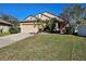 House exterior featuring a two-car garage and neatly landscaped yard at 9564 Venezia Plantation Dr, Orlando, FL 32829