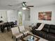 Comfortable living room with leather seating and large windows at 9564 Venezia Plantation Dr, Orlando, FL 32829