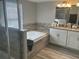 Bright bathroom featuring double sinks, a tiled bathtub, and a glass shower enclosure at 1341 Shinnecock Hills Dr, Davenport, FL 33896