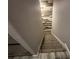 Carpeted staircase descending with a decorative wood accent wall for character at 1341 Shinnecock Hills Dr, Davenport, FL 33896