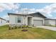 New construction home with gray siding, light stone accents, and a two-car garage at 2121 Rosewood Dr, Bartow, FL 33830