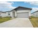 New construction home with gray siding, light stone accents, and a two-car garage at 2121 Rosewood Dr, Bartow, FL 33830