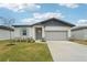 One-story home with gray siding, light stone accents, and a two-car garage at 2121 Rosewood Dr, Bartow, FL 33830