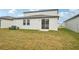 Home's backyard with grassy lawn and AC unit at 2137 Rosewood Dr, Bartow, FL 33830
