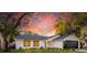 Stunning curb appeal at sunset. This renovated home boasts a modern design and beautiful landscaping at 1704 Ison Ln, Ocoee, FL 34761