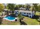 Aerial view of a backyard featuring a kidney-shaped pool, patio, and a well-maintained lawn at 4317 Ne 12Th St, Ocala, FL 34470