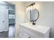 Bathroom with a vanity with a modern faucet and a round mirror, with a doorway behind at 4317 Ne 12Th St, Ocala, FL 34470
