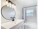 Bright bathroom with round mirror, modern fixtures, and tiled shower-tub at 4317 Ne 12Th St, Ocala, FL 34470
