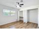 Bedroom featuring new floors, a ceiling fan, a closet, and a bright window at 4317 Ne 12Th St, Ocala, FL 34470