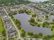 Aerial view of community featuring a large pond, lush landscaping, and colorful homes at 5342 Horton Ln, Orlando, FL 32814