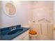 A full bathroom with a walk-in tub, a white toilet with a wood seat and a blue vanity with a mirror at 5342 Horton Ln, Orlando, FL 32814
