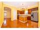 Bright eat-in kitchen with wood cabinets, an island, stainless appliances and a decorative chandelier at 5342 Horton Ln, Orlando, FL 32814