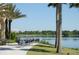Picturesque lakeside dining area with tables and chairs, surrounded by palm trees and offering serene water views at 5342 Horton Ln, Orlando, FL 32814