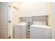A laundry room has a washer, a dryer and white cabinets above the machines at 5342 Horton Ln, Orlando, FL 32814