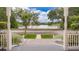 Porch view of a tranquil lake with mature trees, green grass and a street in front at 5342 Horton Ln, Orlando, FL 32814