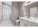 Bathroom with white vanity, mirror, and tile flooring, complete with a glass door shower at 571 Masalo Pl, Lake Mary, FL 32746