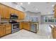 Bright kitchen with stainless steel appliances, granite counters, and tile flooring at 571 Masalo Pl, Lake Mary, FL 32746