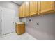 Bright laundry room features cabinets, a utility sink, and white marble-look tile floors at 571 Masalo Pl, Lake Mary, FL 32746