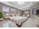 Main bedroom featuring a tray ceiling, large bed, and marble tile flooring at 571 Masalo Pl, Lake Mary, FL 32746
