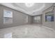 Spacious main bedroom featuring tray ceiling, recessed lights, windows and white tile floors at 571 Masalo Pl, Lake Mary, FL 32746