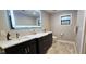 Modern bathroom featuring dual sinks, a large, lit mirror, and stylish gray tile flooring at 1660 Killean Ct, Apopka, FL 32712