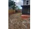 Fenced backyard with red mulch, a wooden deck, and a view of the house at 4530 Brook Hollow Cir, Winter Springs, FL 32708