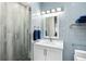 Clean bathroom with white vanity and blue tile shower at 7811 Skiing Way, Winter Garden, FL 34787