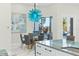 Elegant dining area with glass table and unique blue chandelier at 7811 Skiing Way, Winter Garden, FL 34787