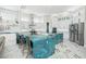 Modern kitchen with white cabinets, blue quartz island, and stainless steel appliances at 7811 Skiing Way, Winter Garden, FL 34787