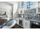 Modern wet bar with wine cooler, quartz countertops, and stylish tile backsplash at 7811 Skiing Way, Winter Garden, FL 34787