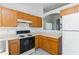 Kitchen featuring wood cabinets, countertops, appliances and a window overlooking the living space at 14216 Boca Key Dr, Orlando, FL 32824