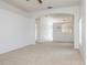 Open-concept living room featuring neutral carpet, white walls and an arched doorway at 14216 Boca Key Dr, Orlando, FL 32824