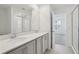 Bathroom features double sink vanity with stone countertop, large mirror, and separate room for shower at 2378 Broadbrook Dr, St Cloud, FL 34771